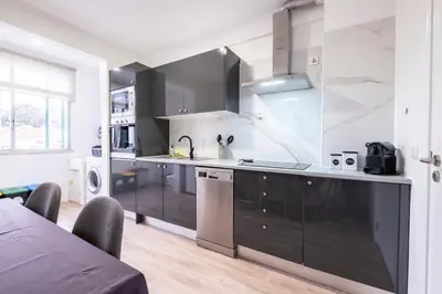 a kitchen with black and white cabinets and appliances at Lux City Center Apartment 2 in Funchal