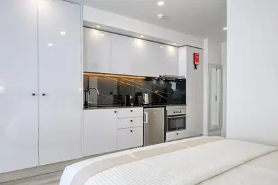 a white kitchen with white cabinets and a stove at BSE15 Apartments 1B, a Home in Madeira in Funchal