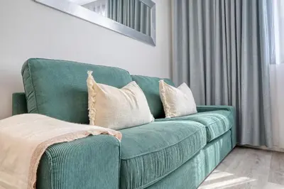 a green couch with pillows in a living room at BSE15 Apartments 1B, a Home in Madeira in Funchal