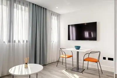 a living room with two chairs and a table and a tv at BSE15 Apartments 1B, a Home in Madeira in Funchal