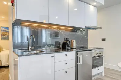 a kitchen with white cabinets and stainless steel appliances at BSE15 Apartments 1C, a Home in Madeira in Funchal