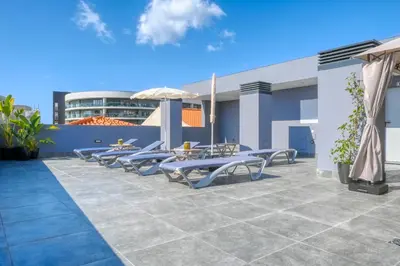 a patio with tables and chairs on a building at BSE15 Apartments 1C, a Home in Madeira in Funchal