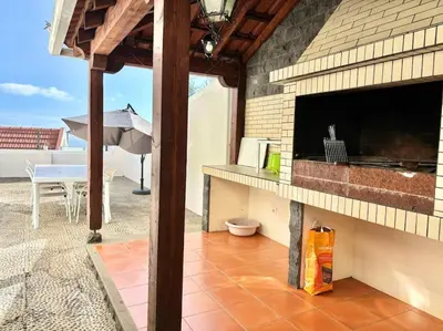 an outdoor patio with a table and an umbrella at Villa Oasis Sea View - 3 Bedrooms in Funchal
