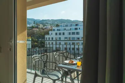 a balcony with a table with a pizza on it at Art Studio by Atlantic Holiday in Funchal