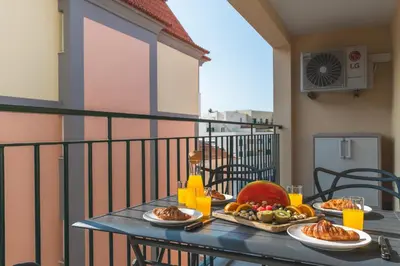 a table with plates of food on a balcony at Art Studio by Atlantic Holiday in Funchal