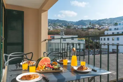 a table with food and drinks on a balcony at Art Studio by Atlantic Holiday in Funchal