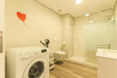 a laundry room with a washing machine with a heart on the wall at Art Studio by Atlantic Holiday in Funchal