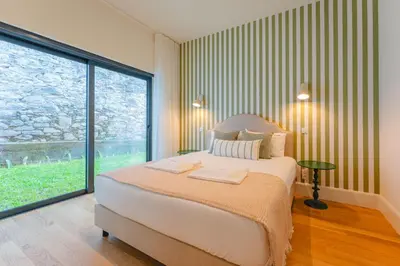 a bedroom with a large bed and a large window at FLH Funchal A Quinta do Conde in Funchal