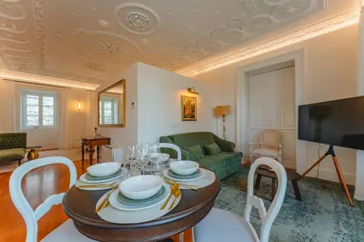 a living room with a table and a tv at FLH Funchal A Quinta do Conde in Funchal