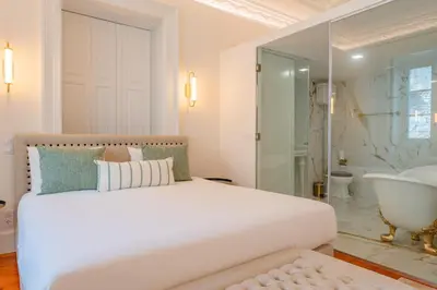 a bedroom with a large white bed and a bath tub at FLH Funchal A Quinta do Conde in Funchal