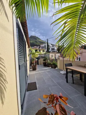 a patio with a table and a bench on a building at Favinha Rooftop in Machico