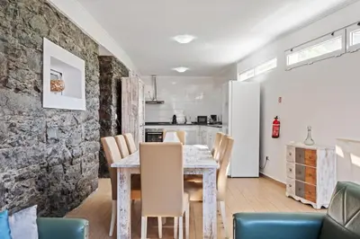 a kitchen and dining room with a table and chairs at Casa da Avó Paraíso in Machico