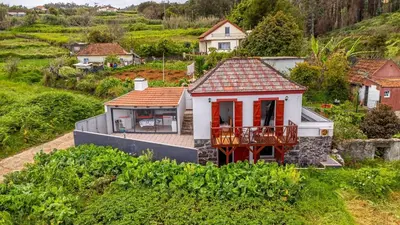 a small house with a balcony in a village at Moniz Ocean Escape BBQ Near Porto Moniz Pools in Porto Moniz
