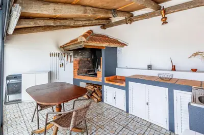 a kitchen with a table and a brick oven at Moniz Ocean Escape BBQ Near Porto Moniz Pools in Porto Moniz