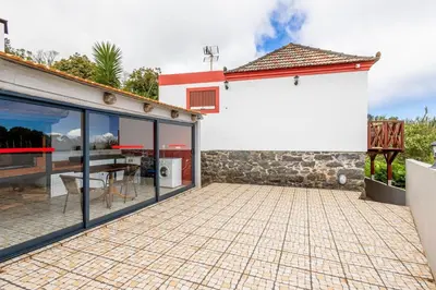 a house with a patio and a dining area at Moniz Ocean Escape BBQ Near Porto Moniz Pools in Porto Moniz