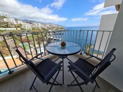 a balcony with a table and two chairs and the ocean at Step To The Sea 4, by Pausa Holiday Rentals in Funchal