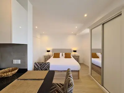 a bedroom with two beds and a living room at Step To The Sea 4, by Pausa Holiday Rentals in Funchal