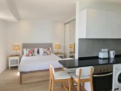 a bedroom with a bed and a kitchen with a table at Step To The Sea 5, by Pausa Holiday Rentals in Funchal