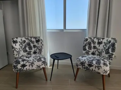 two chairs and a table in front of a window at Step To The Sea 5, by Pausa Holiday Rentals in Funchal