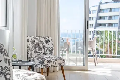 a room with chairs and a table and a balcony at Step To The Sea 5, by Pausa Holiday Rentals in Funchal