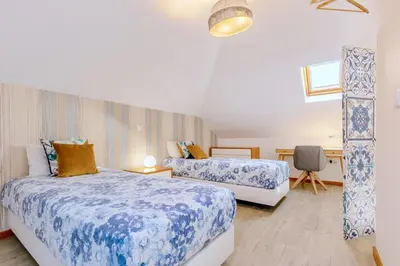 a bedroom with two beds with blue and white sheets at Villa Miradouro da Baleia (Heated Pool optional) in Ponta do Sol
