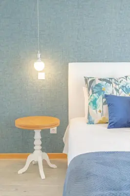 a bedroom with a table next to a bed at Villa Miradouro da Baleia (Heated Pool optional) in Ponta do Sol