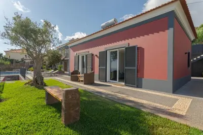 a house with a bench in front of it at Villa Miradouro da Baleia (Heated Pool optional) in Ponta do Sol