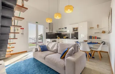 a living room with a couch and a table at Villa Miradouro da Baleia (Heated Pool optional) in Ponta do Sol
