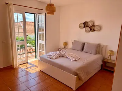 a bedroom with a bed with areath on the wall at Oliveira's Home in Porto Santo
