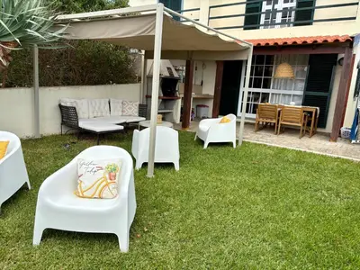 a group of chairs and tables under an umbrella at Oliveira's Home in Porto Santo