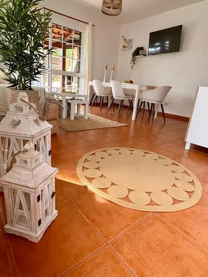 a living room with a table and chairs and a rug at Oliveira's Home in Porto Santo