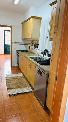 a kitchen with wooden cabinets and a stainless steel stove at Oliveira's Home in Porto Santo