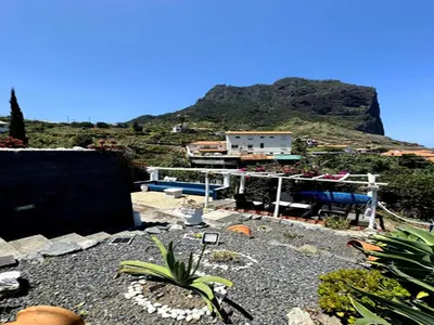 a view of a house with a mountain in the background at Studio in Porto da Cruz with Ocean Views in Porto da Cruz