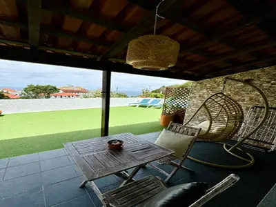 a patio with a table and chairs and a field at Studio in Porto da Cruz with Ocean Views in Porto da Cruz