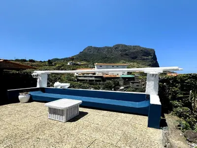a bench sitting on top of a roof with a mountain at Studio in Porto da Cruz with Ocean Views in Porto da Cruz
