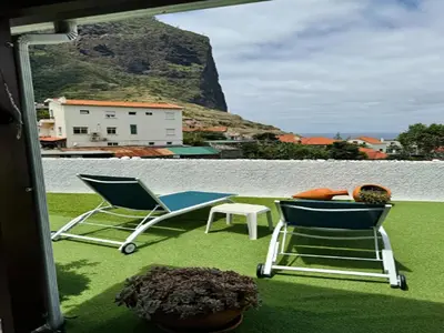 a pair of chairs and a table on a balcony at Studio in Porto da Cruz with Ocean Views in Porto da Cruz