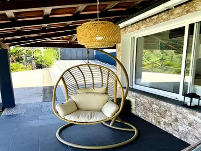 a hanging rattan chair on a porch at Holiday home in Porto da Cruz with garden in Porto da Cruz