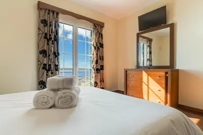 a bedroom with a bed with a mirror and a dresser at Villa Nobrega by Holiday Rental Madeira in Funchal