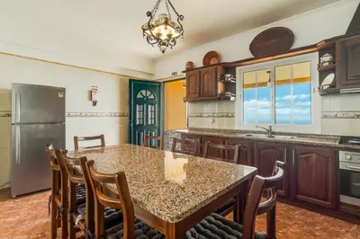 a kitchen with a table and chairs and a refrigerator at Villa Nobrega by Holiday Rental Madeira in Funchal