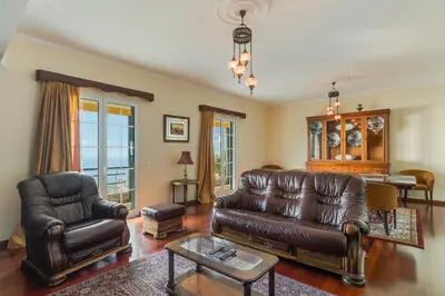 a living room with a leather couch and a table at Villa Nobrega by Holiday Rental Madeira in Funchal