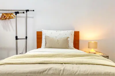 a bedroom with a large bed and a lamp at Casa do Pinheiro I, a Home in Madeira in São Vicente