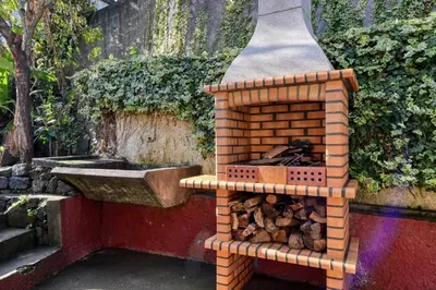a brick barbecue with a sink on top of it at Casa do Pinheiro I, a Home in Madeira in São Vicente