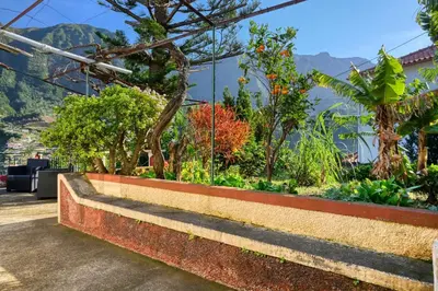 a bench in a garden with mountains in the background at Casa do Pinheiro I, a Home in Madeira in São Vicente