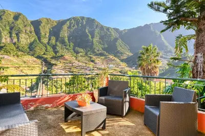 a balcony with chairs and a view of mountains at Casa do Pinheiro I, a Home in Madeira in São Vicente
