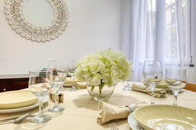 a table with wine glasses and a vase of flowers at Casa do Pinheiro I, a Home in Madeira in São Vicente