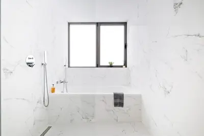 a white bathroom with a tub and a window at Ajuda I - Penthouse by Pausa Holiday Rentals in Funchal