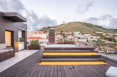 a balcony with stairs and a view of a city at Ajuda I - Penthouse by Pausa Holiday Rentals in Funchal