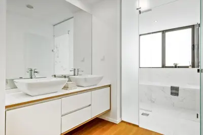 a white bathroom with two sinks and a shower at Ajuda I - Penthouse by Pausa Holiday Rentals in Funchal