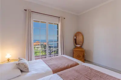 a bedroom with two beds and a large window at Alegria Apart. with Pool, by Pausa Holiday Rentals in Estreito da Calheta