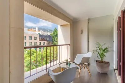 a room with a balcony with a table and two chairs at Stay In Avenue Arriaga 10, by Pausa H. Rentals in Funchal